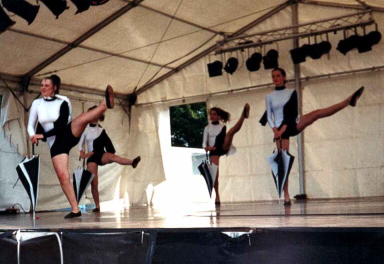 Die Mädels tragen schwarz-weiße Bodys und haben scharz-weiße Regenschirme
