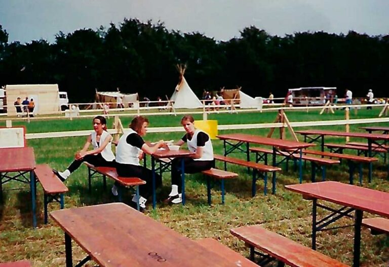 Pause zwischen den Tänzen. Mädels esse Mittag auf Holzbänken.